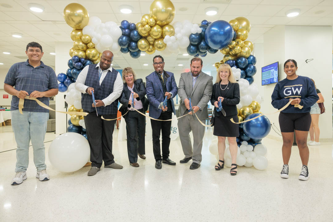 7 people cut the ribbon at District House Dining's grand opening