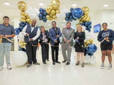 7 people cut the ribbon at District House Dining's grand opening