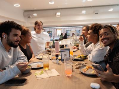 A group of students sit around a table eating in Thurston dining hall